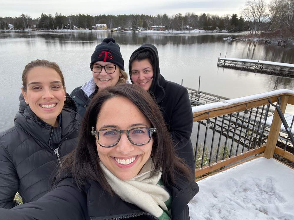 four people posed in a selfie on a dock
