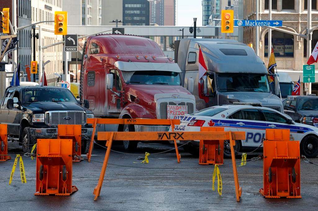 Trucks are blocked by police barricades as a rally against COVID-19 restrictions, which began as a cross-country convoy protesting a federal vaccine mandate for cross-border truckers continues in Ottawa on Tuesday, Feb. 1, 2022. Ottawa police have made two arrests following demonstration-related investigations, as the anti-vaccine mandate protest continues to keep the capital at a standstill. THE CANADIAN PRESS/Patrick Doyle.