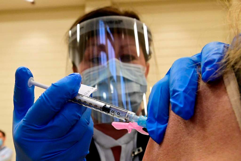 Tamara Dus, director of University Health Network Safety Services, administers a Pfizer-BioNTech COVID-19 vaccine in Toronto on Dec. 14, 2020.