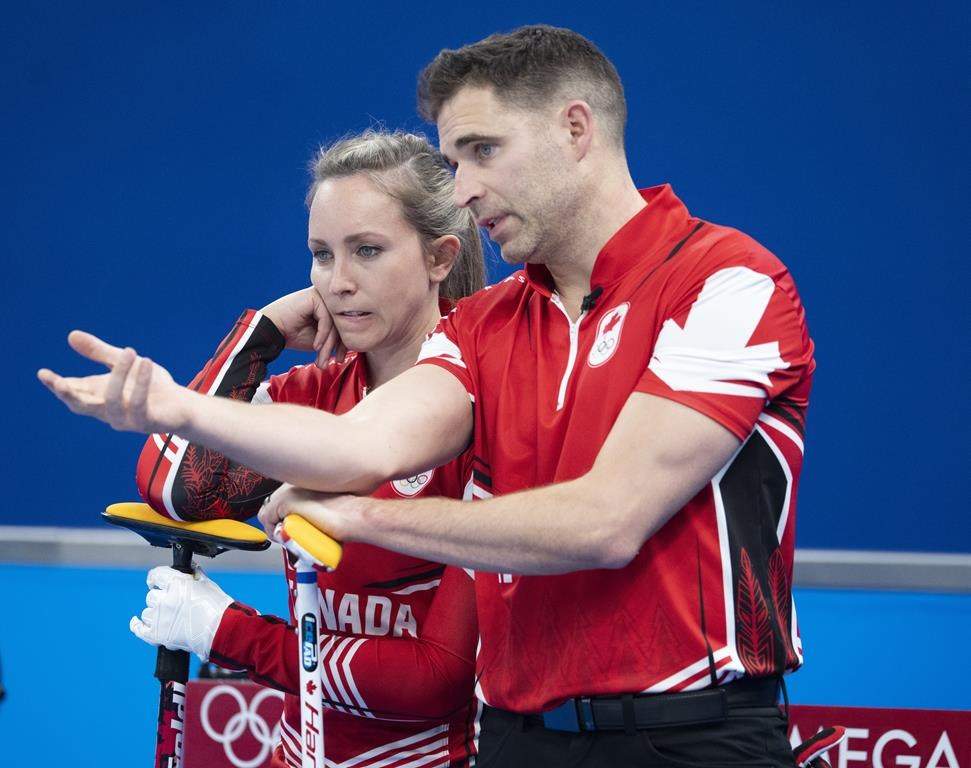 Canada’s Rachel Homan and John Morris discuss a shot during preliminary round mixed curling against the Czech Republic Sunday, Feb. 6, 2022 at the 2022 Winter Olympics in Beijing.