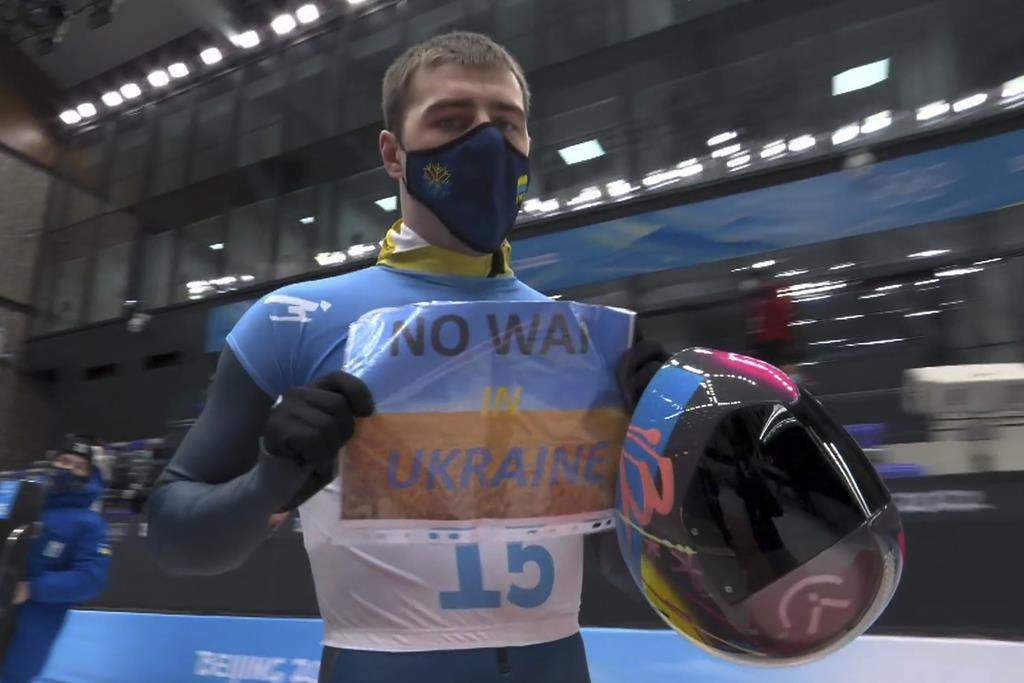 Vladyslav Heraskevych holds a "no war in Ukraine" sign