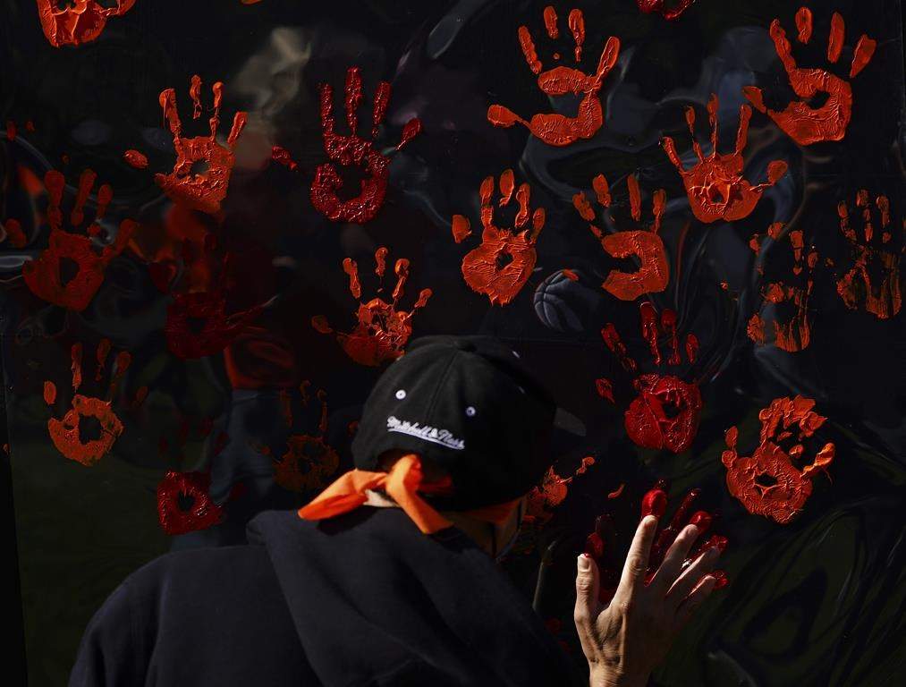 People contribute to a hand painting during the National Day for Truth and Reconciliation in Ottawa on Thursday, Sept. 30, 2021.
