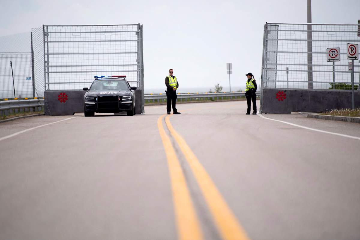 Police guard a gate leading to the green zone at the G7 leader’s summit in La Malbaie, Que. on Thursday, June 7, 2018. THE CANADIAN PRESS/Justin Tang