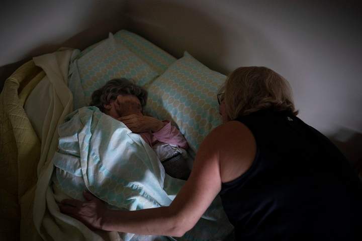 In this Nov. 30, 2021 photo, a woman cares for her mother.
