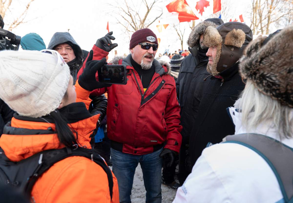 Bernard “Rambo” Gauthier, centre, who organized the convoy to the Quebec legislature, speaks to demonstrators during a protest against COVID-19 restrictions, in Quebec City, Saturday, Feb. 5, 2022.