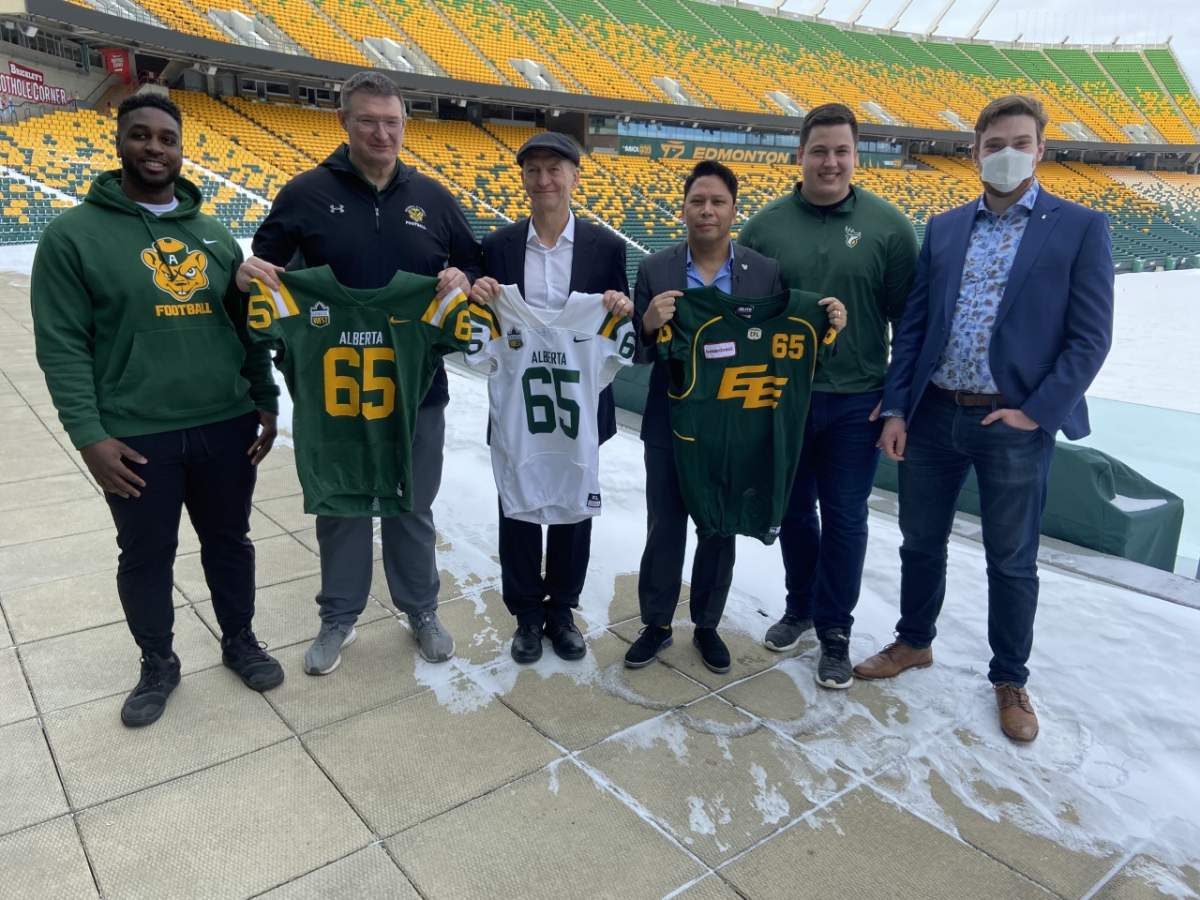 Rodeem Brown, U of A Golden Bears offensive lineman, Chris Morris, U of A Golden Bears head football coach, Ian Reade, U of A director of Athletics, Victor Cui, Edmonton Elks president and CEO, Mark Korte, Edmonton Elks offensive lineman and Rowan Ley, U of A Students’ Union president pose for a photo at Commonwealth Stadium on Feb. 15, 2022.