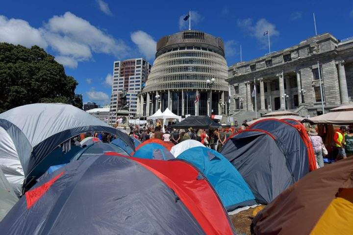 Tents are seen on the grounds of the parliament (behind) as anti-vaccine demonstrators occupy the grounds in Wellington on February 22, 2022.