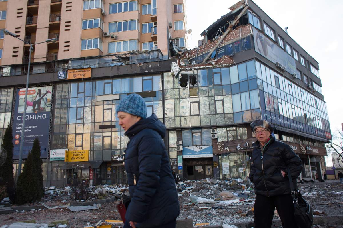 Women pass by the apartment block in 6A Lobanovsky Avenue which was hit with a missile on February 26, 2022 in Kyiv, Ukraine.