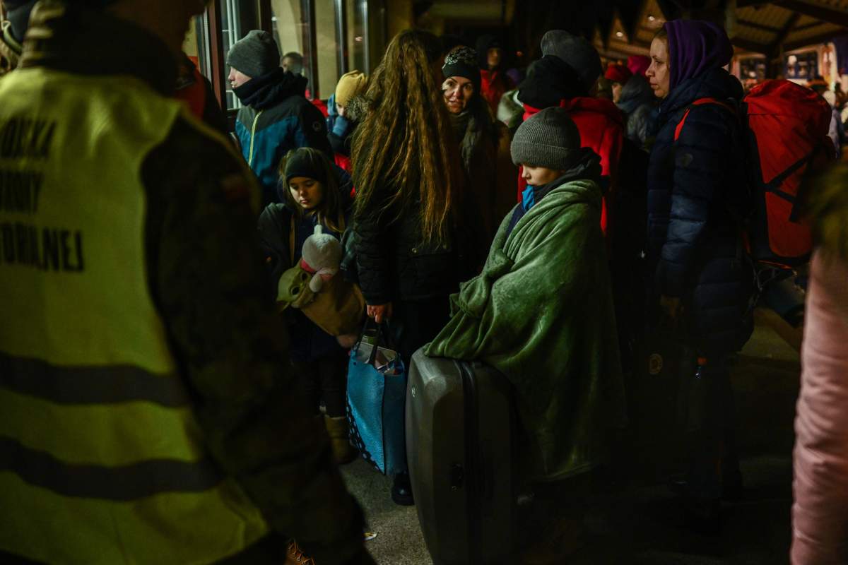People wait to cross the passport control after arriving in a train from Kiev at the Przemysl main train station on February 27, 2022 in Przemysl, Poland.