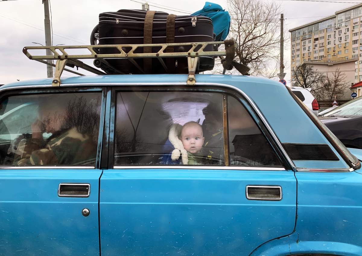 A baby looks out the window of a car during traffic while escaping the Ukrainian capital, Kyiv, during the Russian invasion launched Thurs. Feb. 24, 2022.