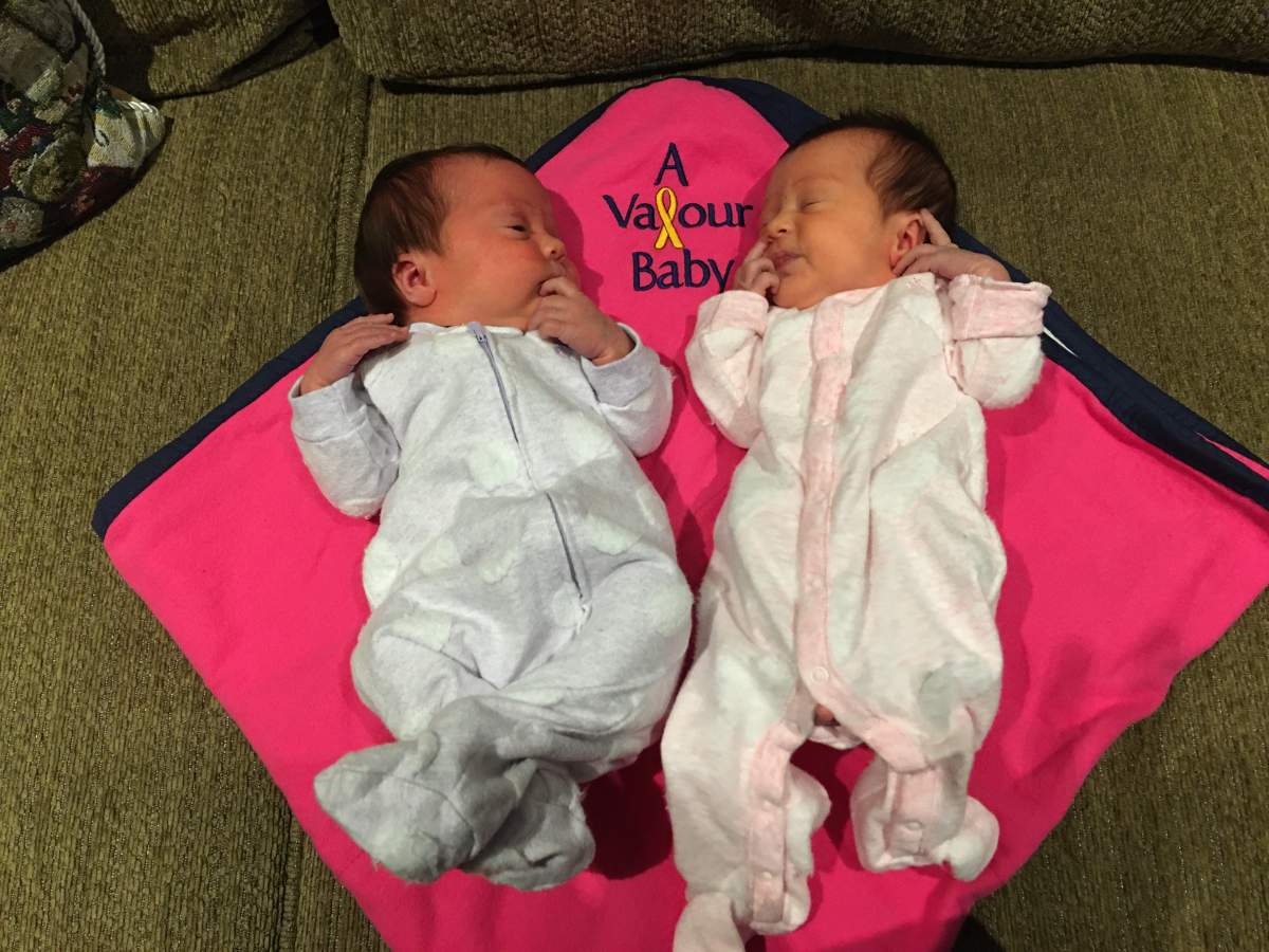 Twins laying on a pink Valour Baby Blanket
