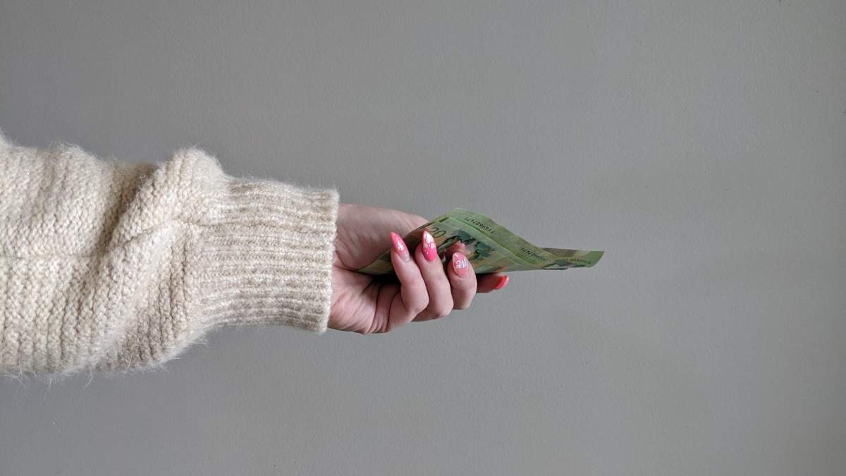 A woman hands over Canadian money.