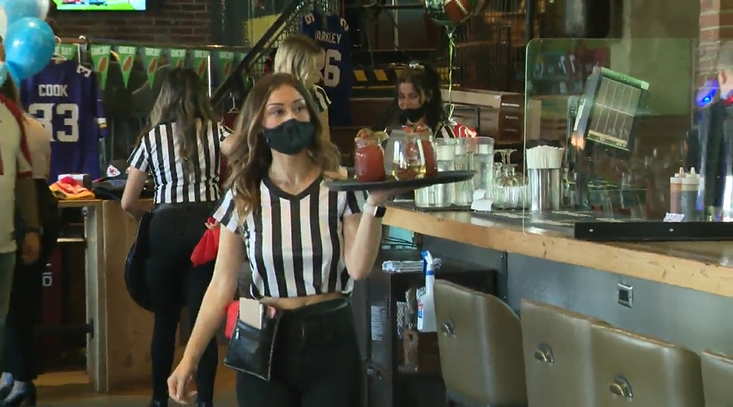 A Shark Club server carries a tray of drinks during the Super Bowl on Sunday. 