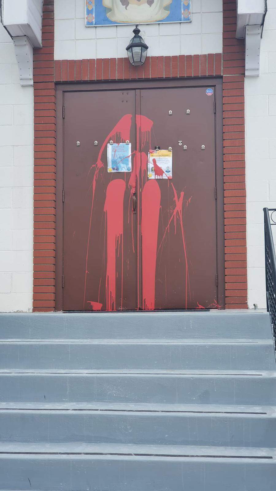 Spray paint on front doors of All Saints Russian Orthodox Church.