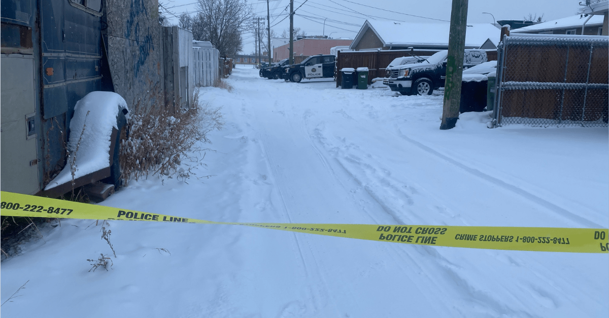 Calgary police tape shown in a snowy back alley on Feb. 21, 2022.