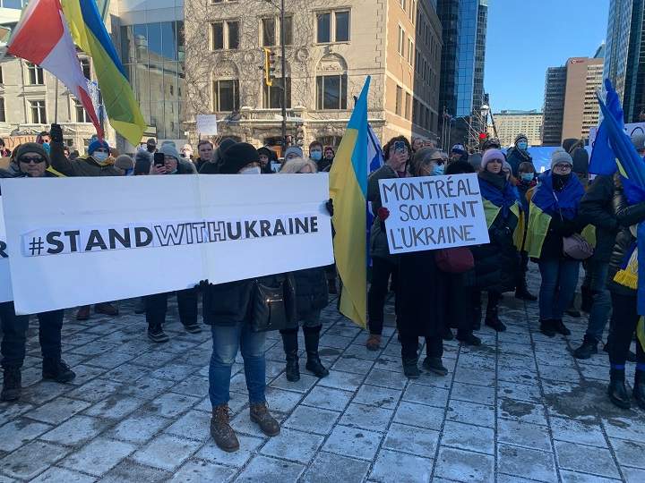 People carry signs showing their support for Ukraine at a protest in downtown Montreal. Thursday Feb. 24, 2022. Olivia O’Malley/Global News