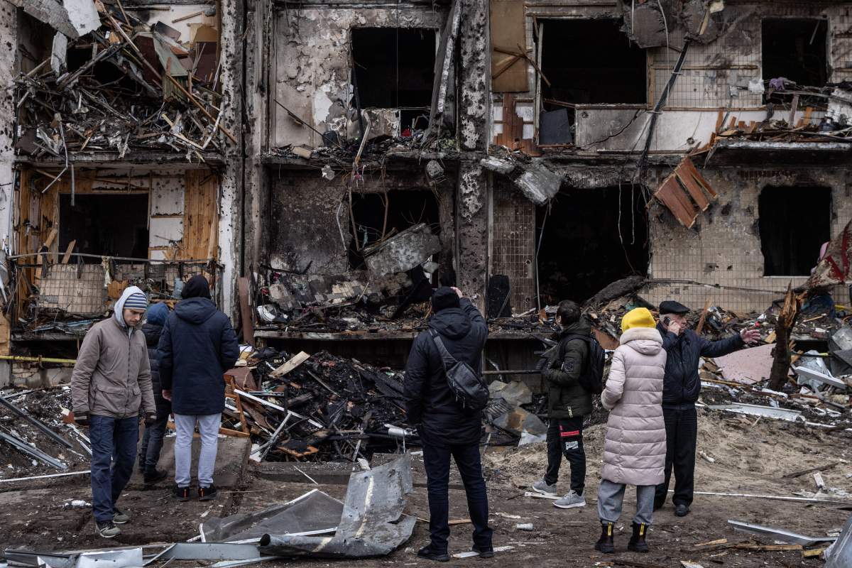 People look at the exterior of a damaged residential block hit by an early morning missile strike Feb. 25 in Kyiv, Ukraine.