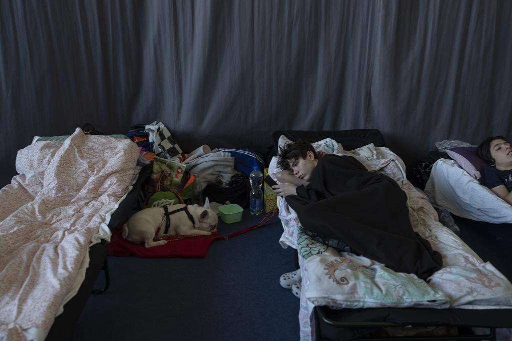 People who fled the war in Ukraine rest inside an indoor sports stadium of a high school in Przemysl, southeastern Poland, on Friday March 18, 2022.