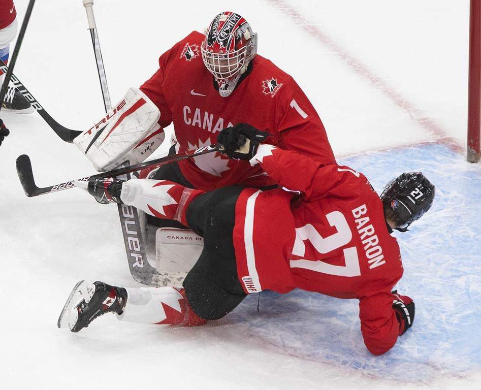 Canada's Justin Barron (27) crashes into his goalie Devon Levi (1) against Russia during second period IIHF World Junior Hockey Championship action in Edmonton on Monday, January 4, 2021. 