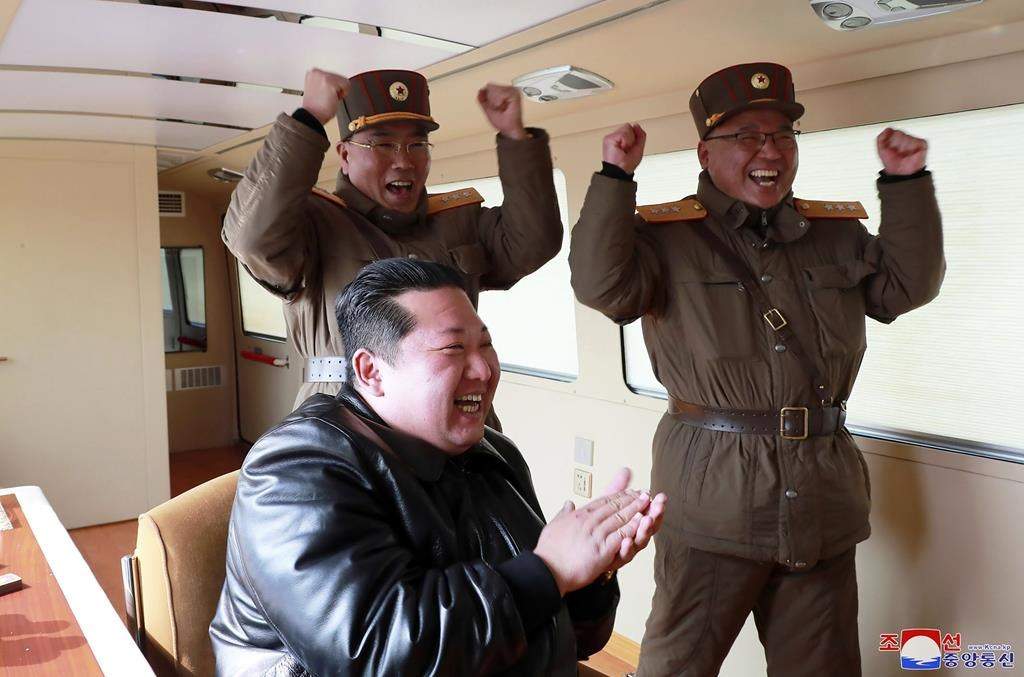 North Korean leader Kim Jong Un, front, claps during a test-fire of what it says is a Hwasong-17 intercontinental ballistic missile (ICBM), at an undisclosed location in North Korea on March 24, 2022.