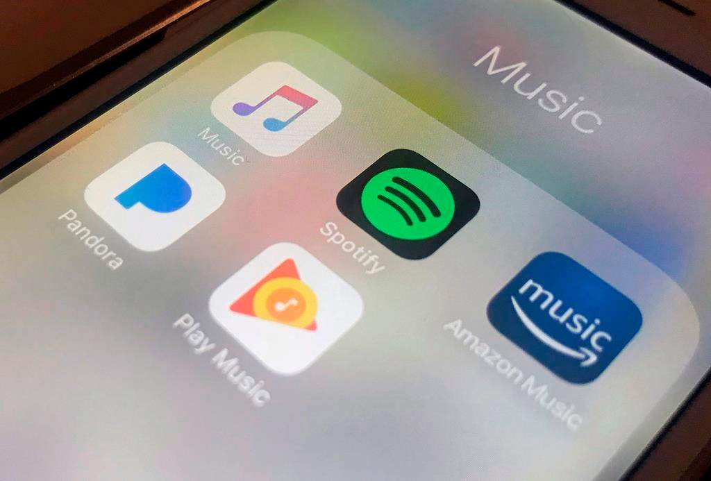 This Sunday, Jan. 28, 2018, photo shows music streaming apps clockwise from top left, Apple, Spotify, Amazon, Pandora and Google on an iPhone in New York. 