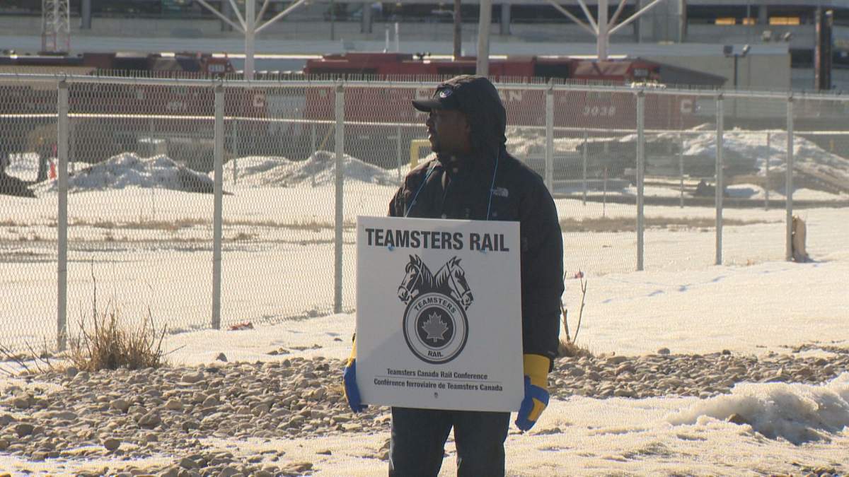 A CP Rail employee walks the picket line on Monday in Regina.