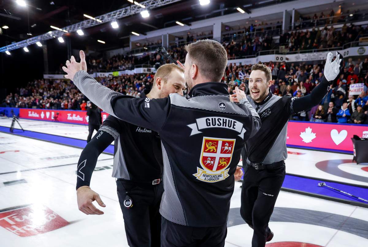 Team Wild Card One skip Brad Gushue, centre, lead Geoff Walker, left, and second Brett Gallant celebrate their victory over Team Alberta at the Tim Hortons Brier in Lethbridge, Alta., Sunday, March 13, 2022.