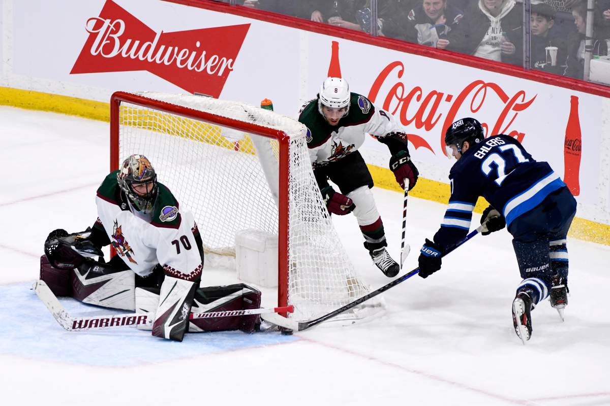 Arizona Coyotes goaltender Karel Vejmelka (70) makes a save on Winnipeg Jets’ Nikolaj Ehlers (27) during the second period of NHL action in Winnipeg on Sunday March 27, 2022.