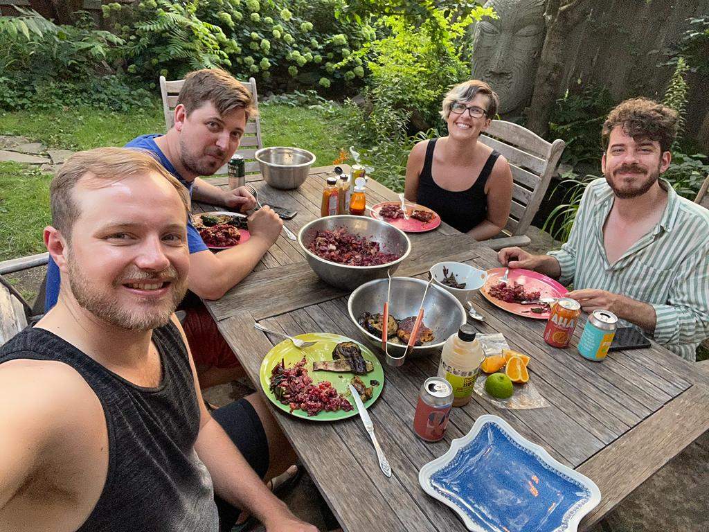 Co-owners of a Toronto home sit down together for a meal in their backyard