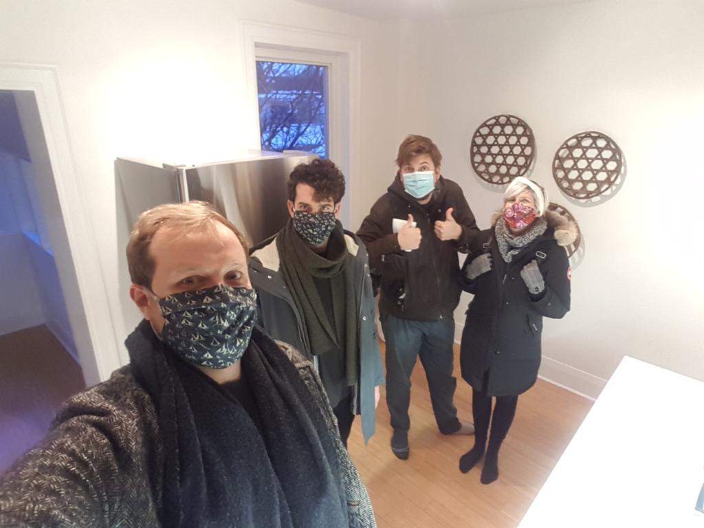 Four millennials pose for the camera inside the house they co-own.
