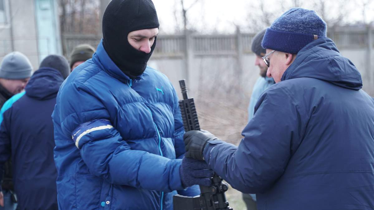 Kirill, left, is a married father of two young daughters, learning to use a firearm in Odesa, Ukraine.