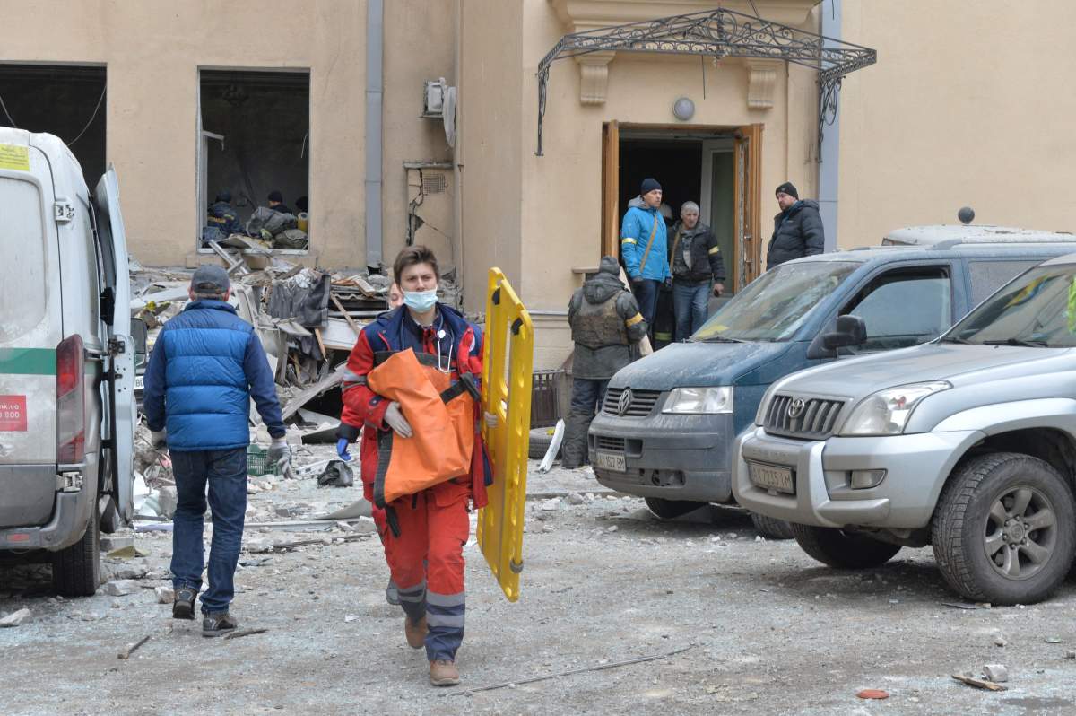 Medics walk outside the damaged local city hall of Kharkiv on March 1, destroyed as a result of Russian troop shelling.