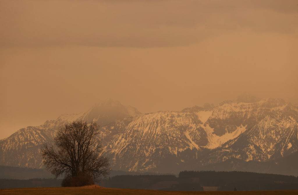 Saharan dust clouds the skies over Bavaria, obscuring the view of a mountain.