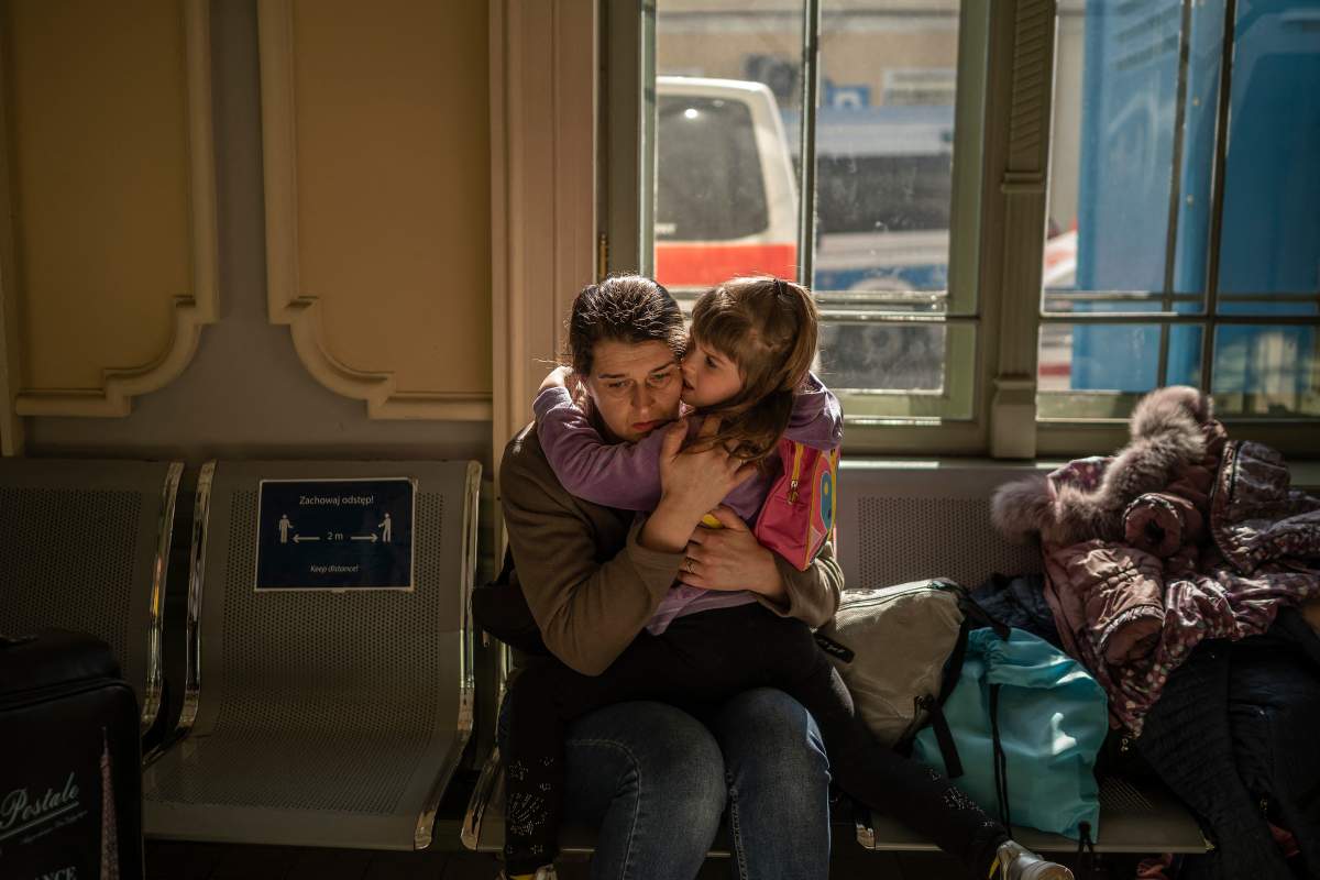 A Ukrainian evacuee hugs a child in the train station in Przemysl, near the Polish-Ukrainian border, on March 22, 2022, following Russia's military invasion launched on Ukraine.