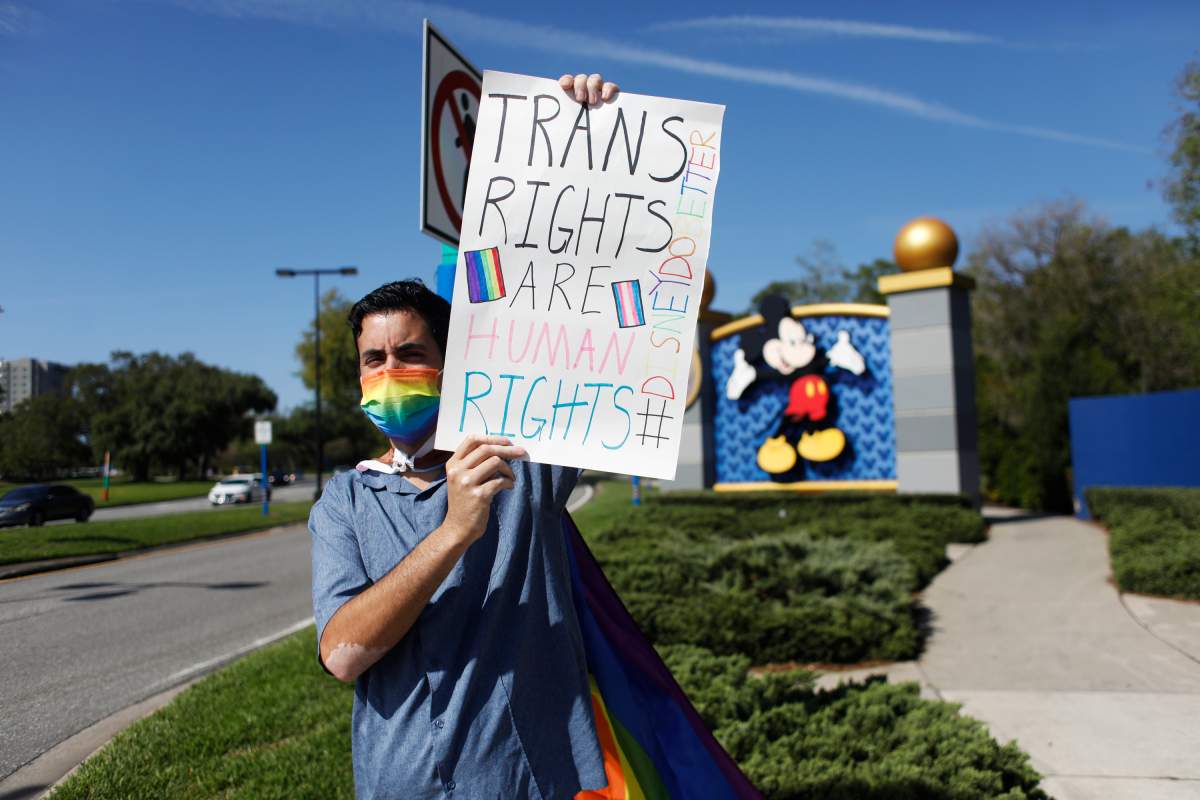 Disney employee Nicholas Maldonado holds a sign that reads "Trans Rights are Human Rights," while protesting outside of Walt Disney World on in Orlando, Florida.