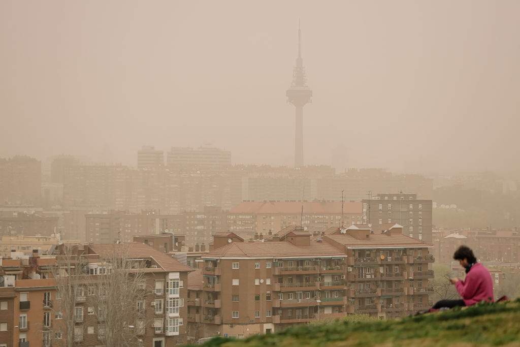 A woman observes the haze of a Saharan dust cloud from the viewpoint of Cerrro del Tio Pio.