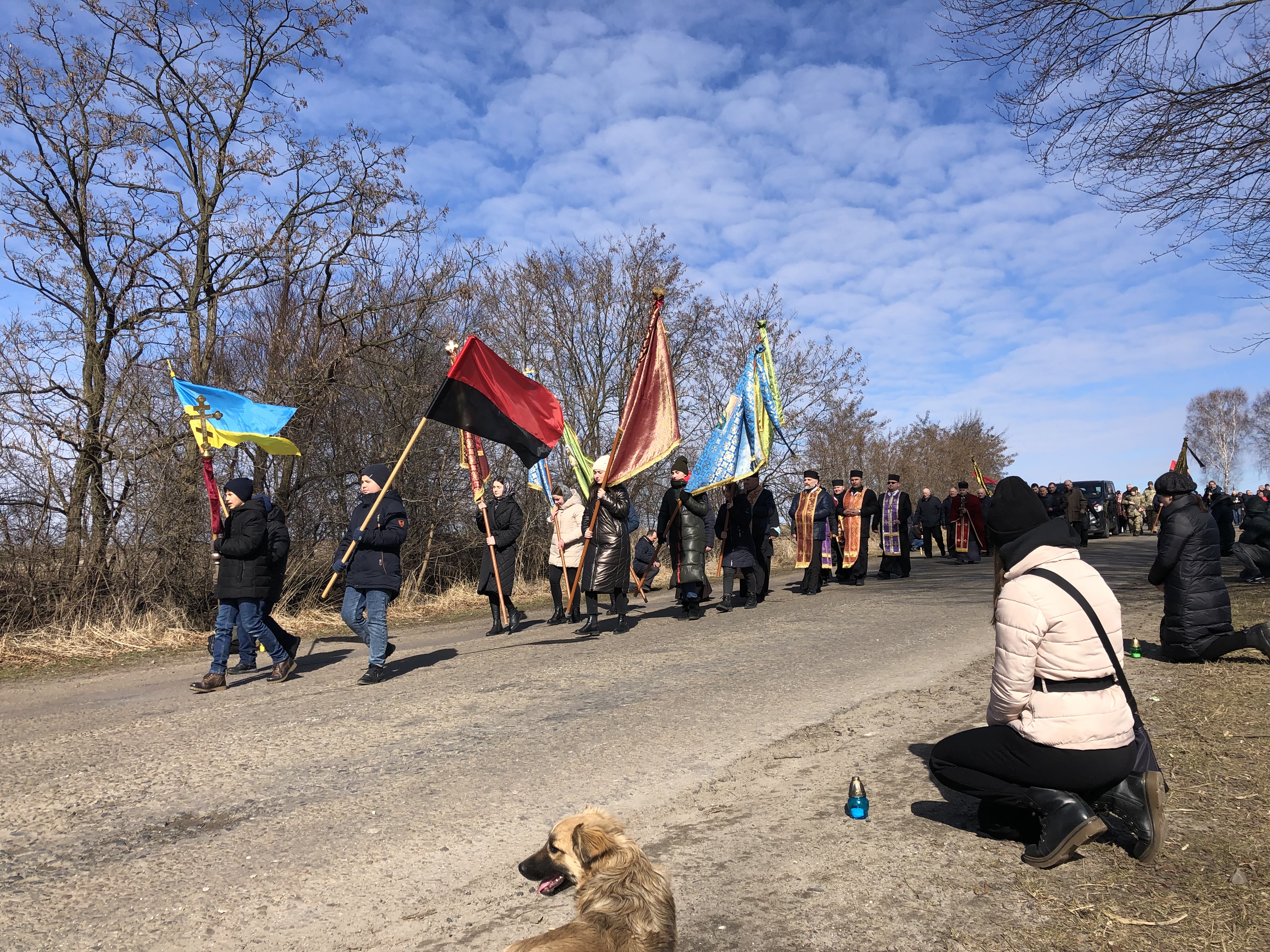 Villagers kneel as body of Ukrainian soldier returns home for burial, March 9, 2022.