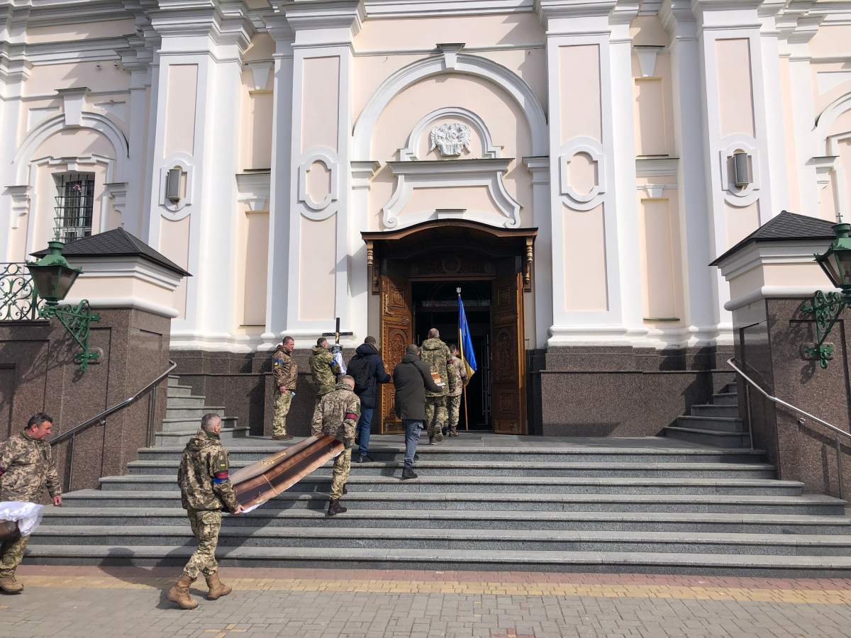 Ukrainian soldiers carry bodies of two comrades killed Friday in Russian missile strike in Lutsk into church, Saturday March 12, 2022.