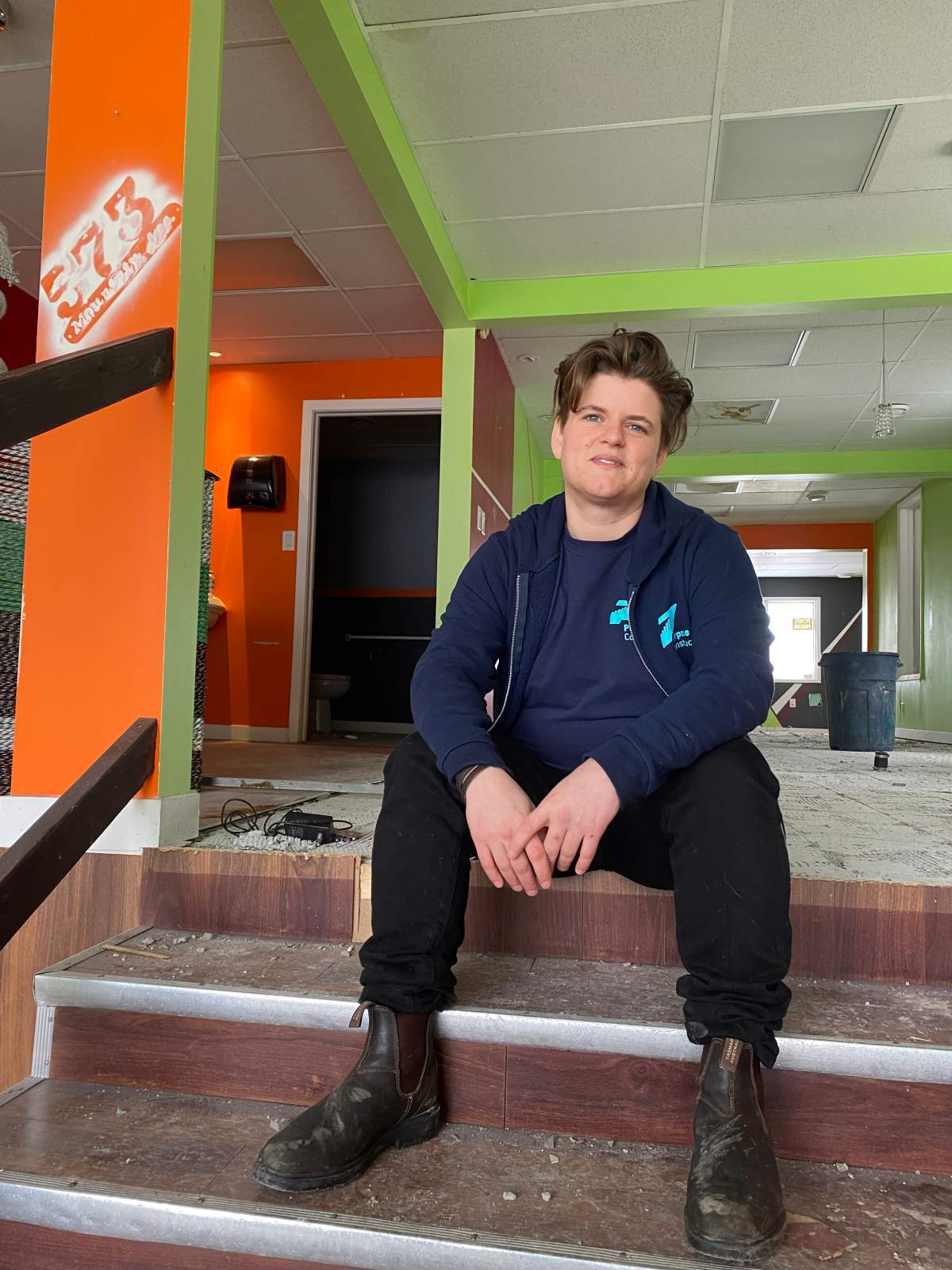 Kalen Taylor, executive director at Purpose Construction, sits on the steps of the main floor to a vacant building on March 23, 2022 waiting to start construction for long-term housing./Michelle Karlenzig