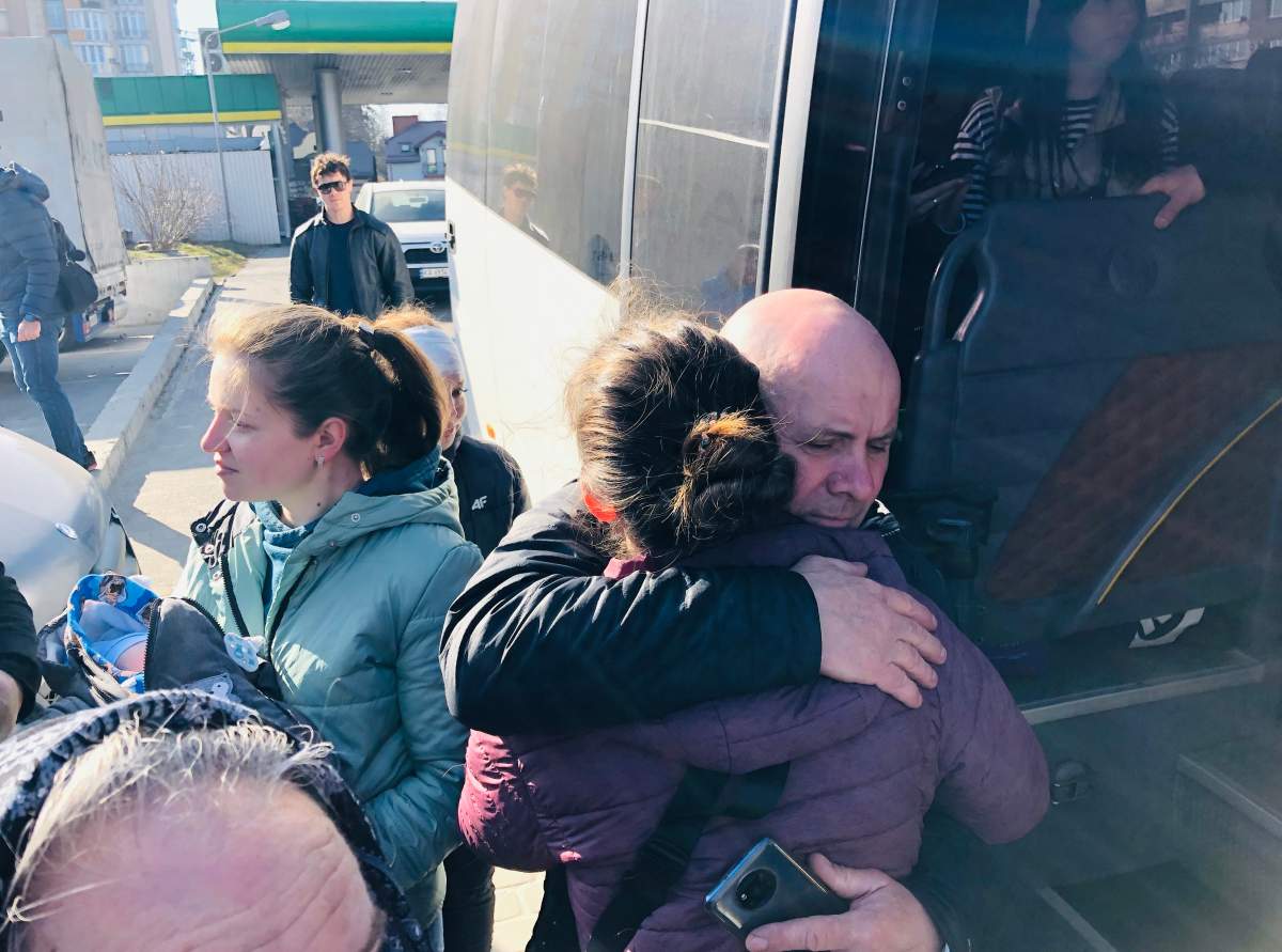 Daria, left, says goodbye to family before boarding a bus to Poland with her one-month-old son.