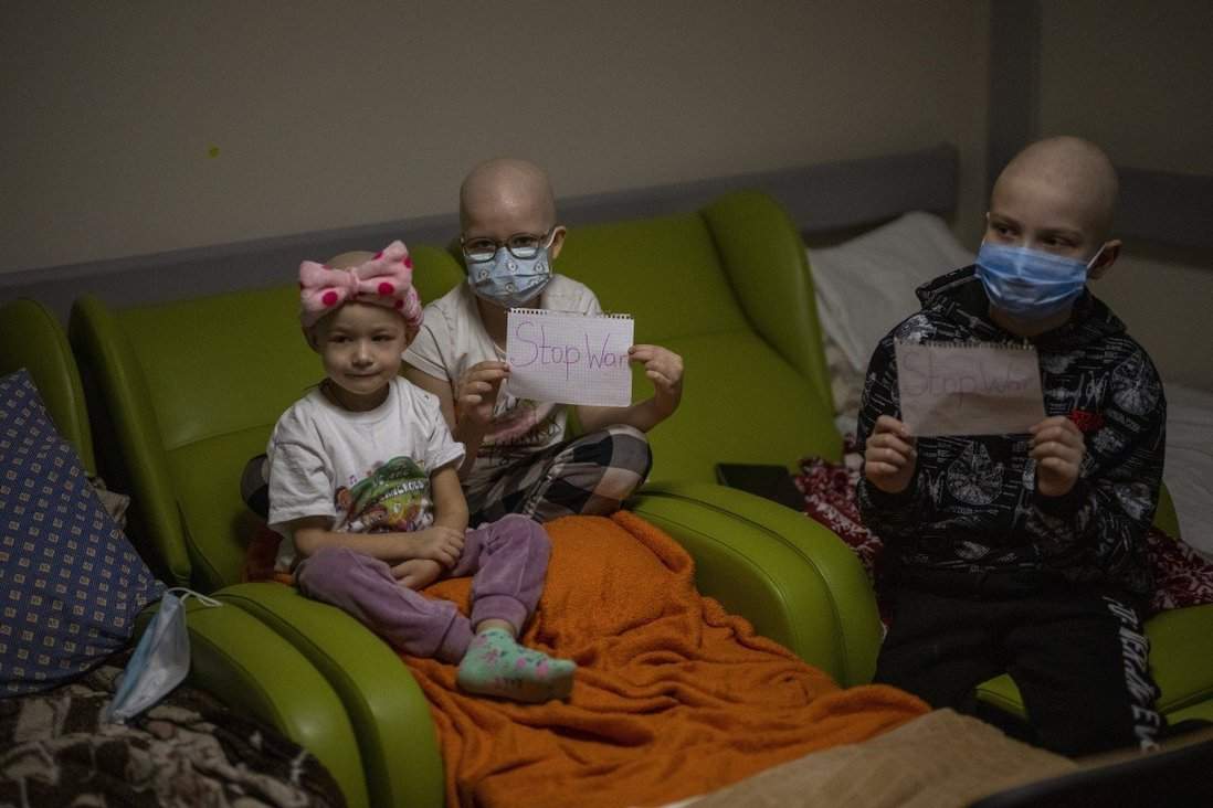 Young cancer patients with a sheet of paper with the words “Stop War” in a basement used as a bomb shelter at the Okhmadet children’s hospital in Kyiv, Ukraine, on Monday, Feb. 28, 2022.