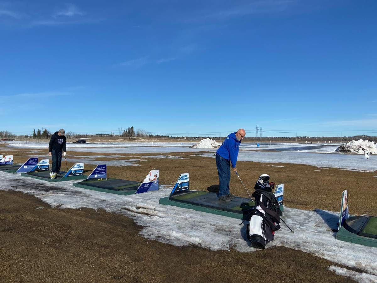 Jim Pearson (R) was ready to hit some balls the moment the Canada Golf Card Driving Range and Mini Golf in southwest Edmonton opened Friday, March 18, 2022.
