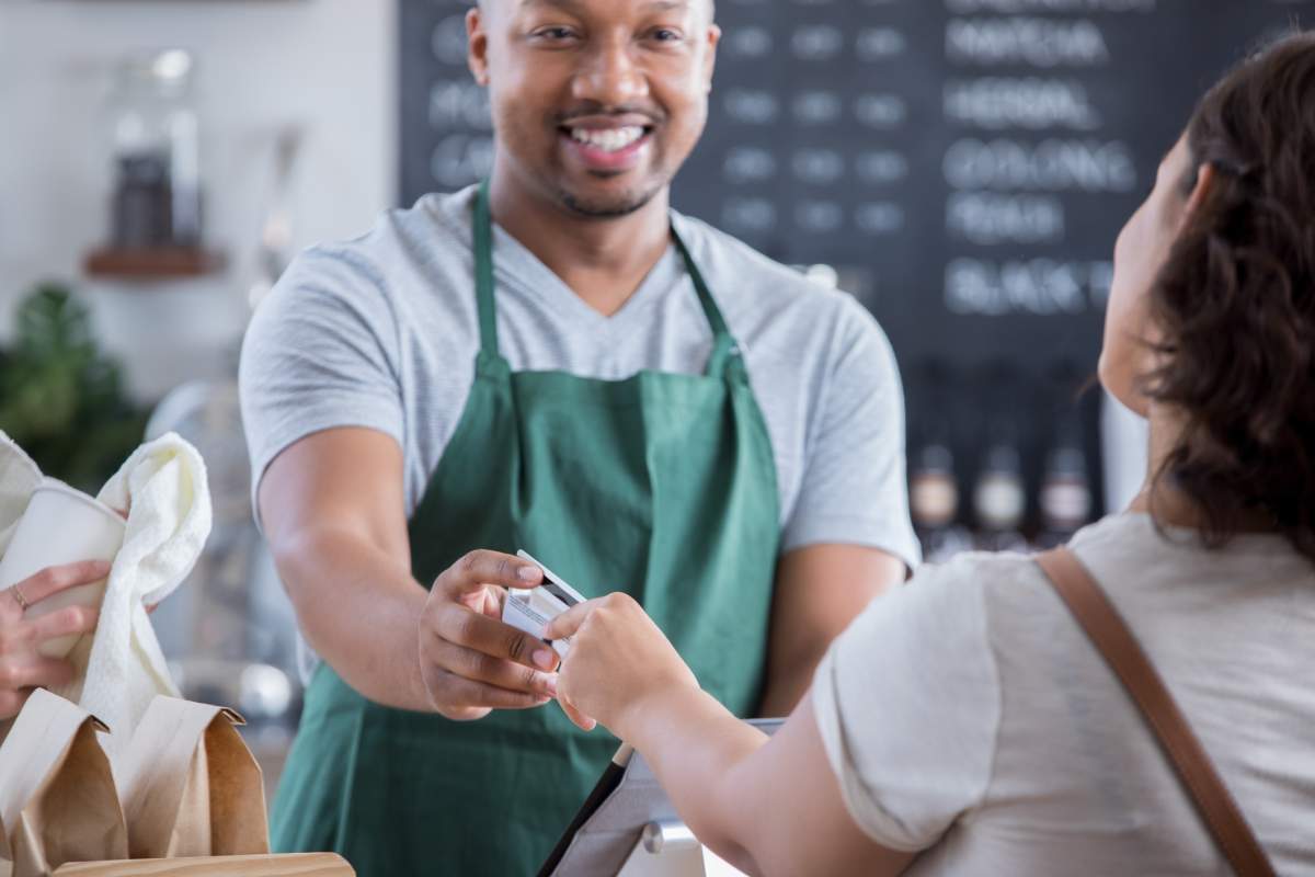 A cashier accepts a customer's credit card