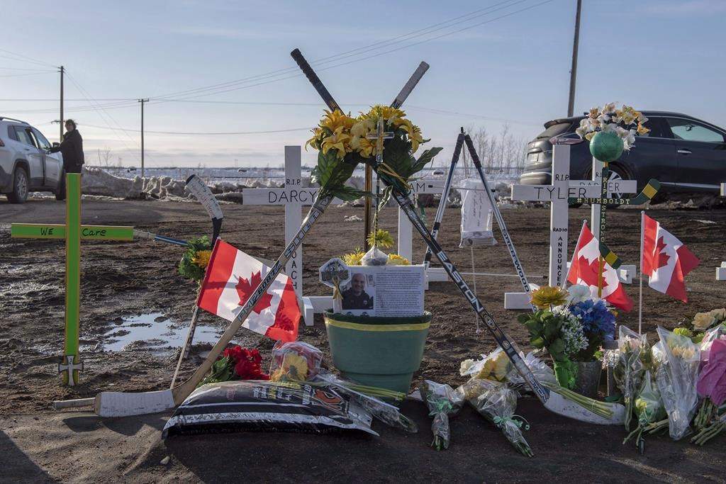 Hockey sticks, messages and other items are seen at a memorial a week after the Humboldt Broncos junior hockey team bus and a transport truck collided at an intersection near Tisdale, Sask. on April 6, 2018.