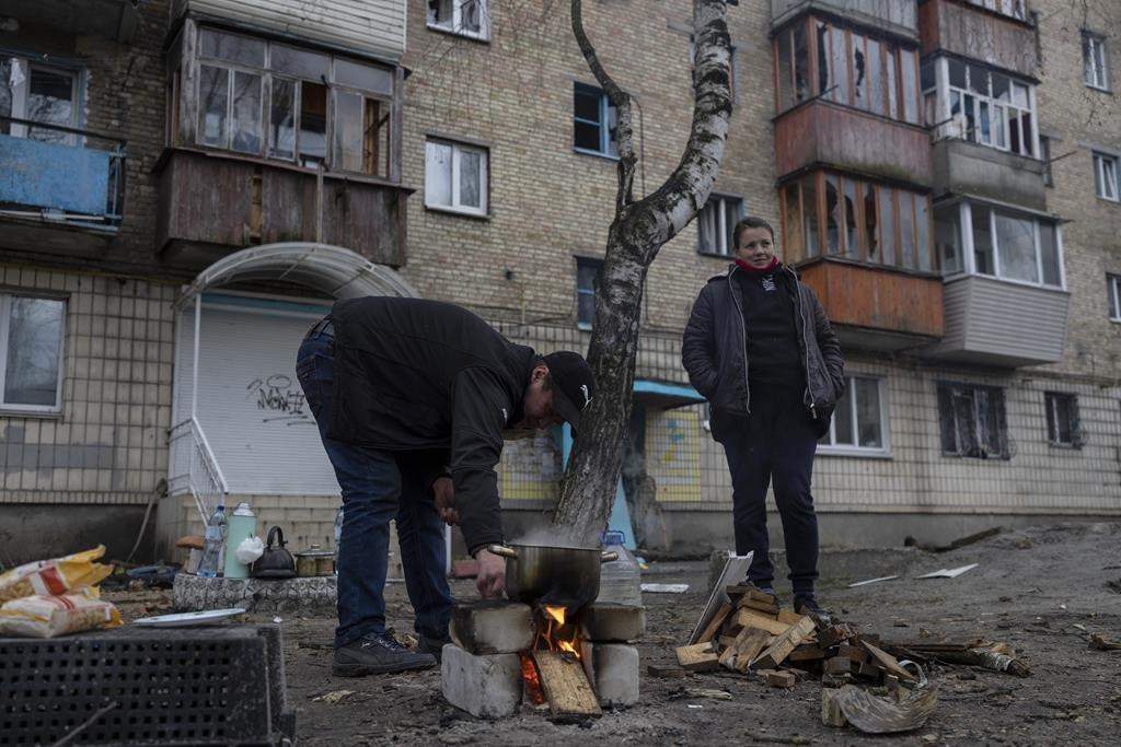 Oleksander Radkevich, 41, cooks on a makeshift fire next to his wife Irina Shekhovtsova outside their destroyed apartment building in the town of Borodyanka, Ukraine, on Saturday, April 9, 2022. Russian troops occupied the town of Borodyanka for weeks. Several apartment buildings were destroyed during fighting between the Russian troops and the Ukrainian forces in the town around 40 miles northwest of Kyiv