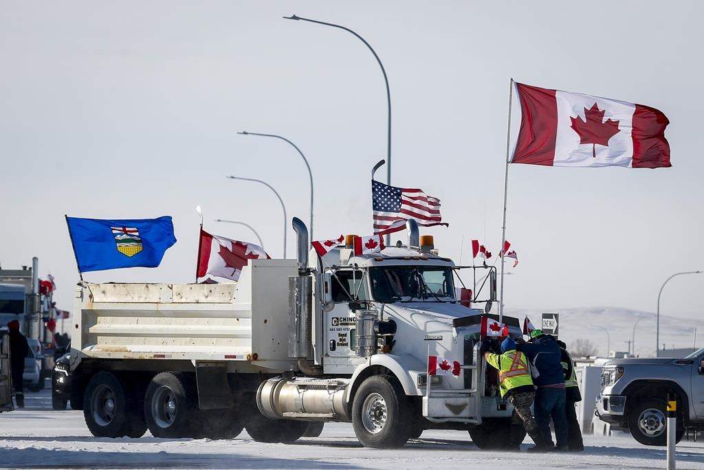 Drivers work to move a gravel truck at a protest blockade at the United States border in Coutts, Alta., Wednesday, Feb. 2, 2022.