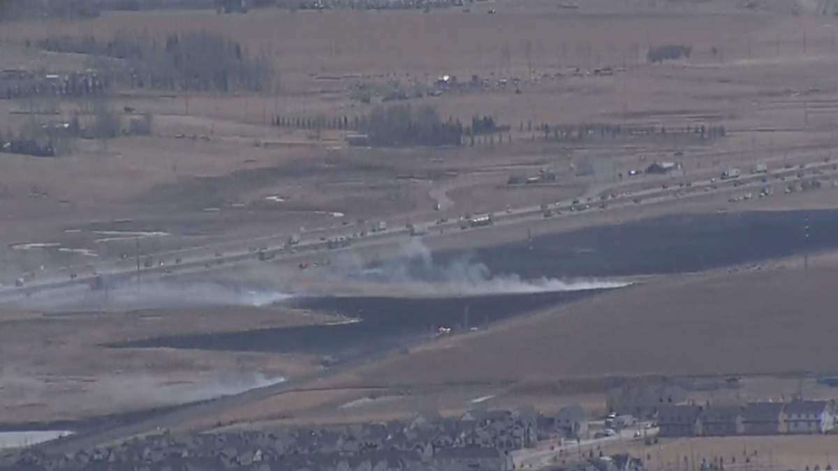A grass fire burns along Highway 2 near Airdrie, Alta., on April 4, 2022.