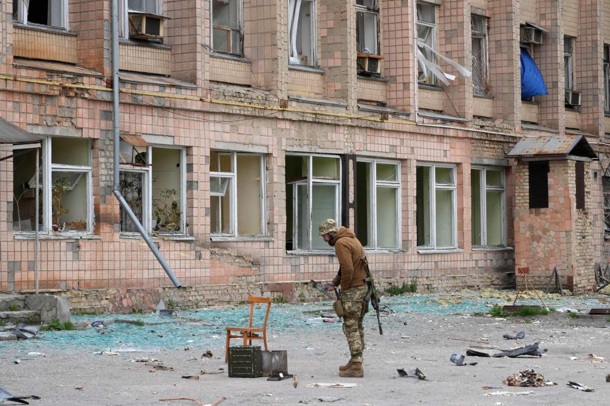 A Ukrainian soldier stands near a state-run nuclear waste department near the Chernobyl nuclear power plant, Ukraine, Saturday, April 16, 2022.