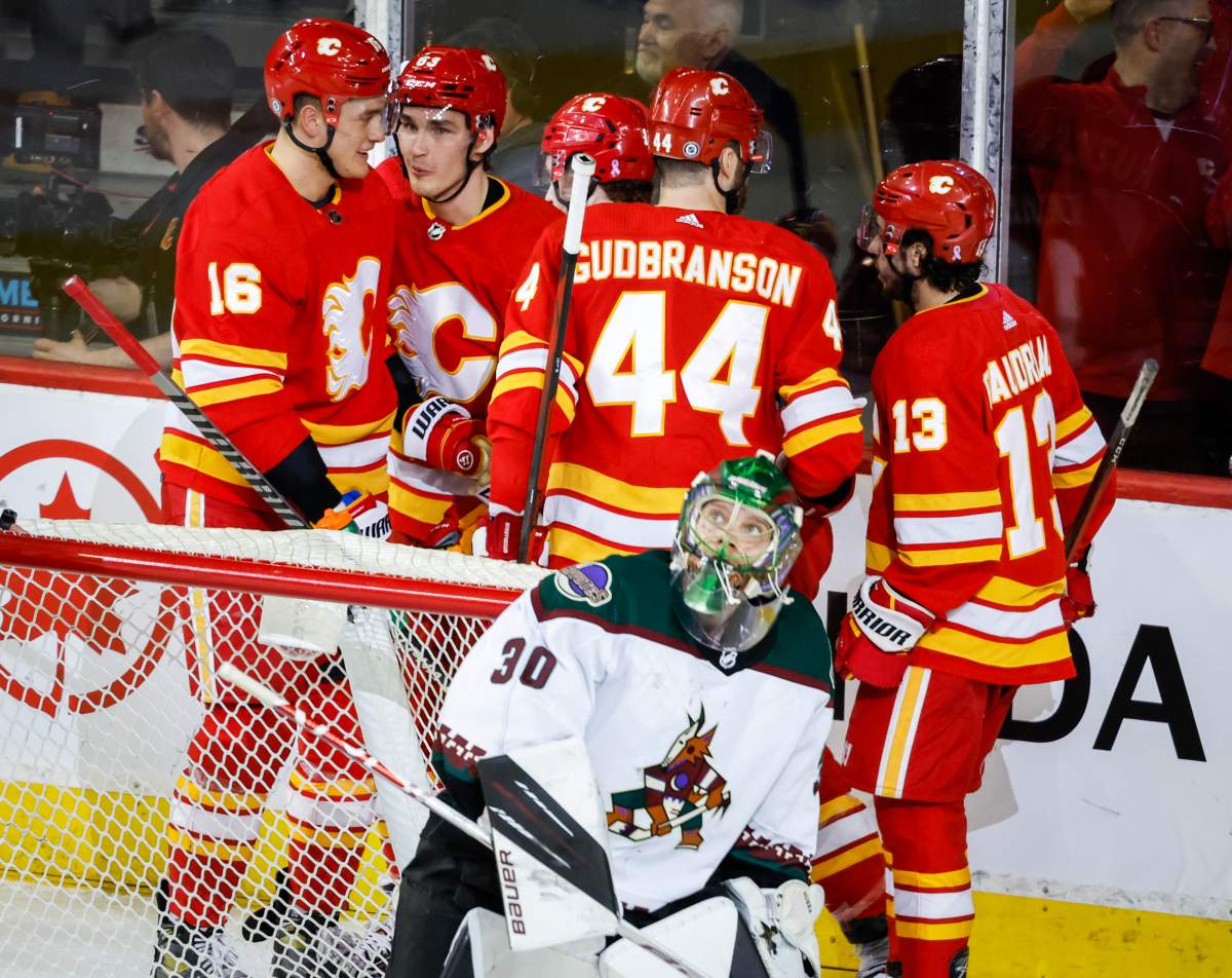 Arizona Coyotes goalie Harri Sateri, centre, looks to the scoreboard as Calgary Flames celebrates a goal during second period NHL hockey action in Calgary, Saturday, April 16, 2022.