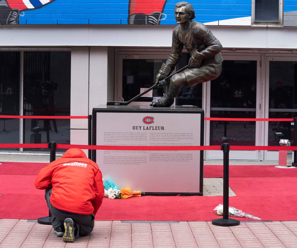 A fan pays their respects in front of a bronze statue outside the Bell Centre, of Canadiens legend Guy Lafleur who passed away, Friday, April 22, 2022, in Montreal.
